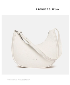Close-up of a white crescent moon underarm bag with grainy leather texture and silver STLY logo