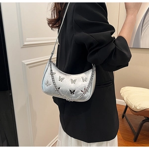 Détails du sac demi-lune argenté brillant avec plis naturels et ornements papillon