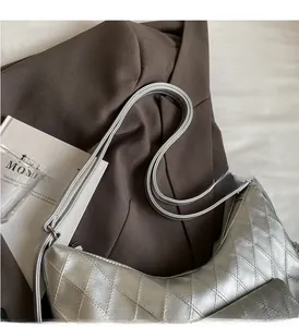Detailed view of silver quilted hobo bag with sleek thin straps on a blazer