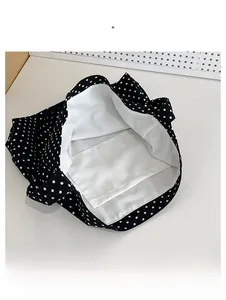 Detailed view of polka dot tote bag interior featuring white lining and inner pocket