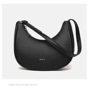 Close-up of black lychee grain leather underarm bag featuring silver STLY logo detail