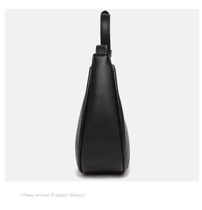 Detail view of the black lychee pattern leather texture on a minimalist underarm bag