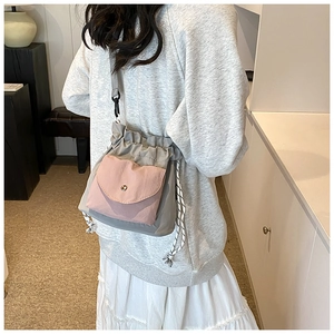 Detail view of stylish drawstring oxford cloth crossbody bag on model back