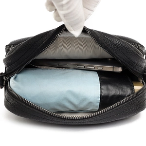 Sac bandoulière en cuir grainé noir avec plusieurs compartiments et un intérieur spacieux