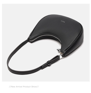 Detailed view of the black pebbled leather texture and silver STLY logo on the underarm bag