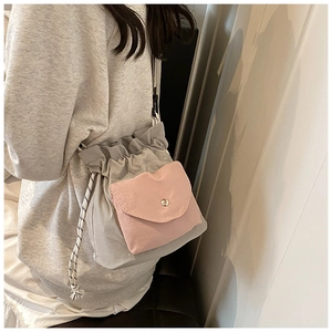Detail view of two-tone bucket bag featuring pink pocket and drawstring closure