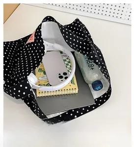 Spacious interior of a black polka dot canvas tote bag organized with tech accessories