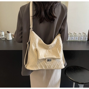 Detail view of a cream PU leather shoulder bag with quilted diamond pattern and silver lock