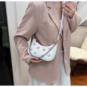 Détail du sac bandoulière demi-lune blanc avec papillons argentés et poignée en chaîne