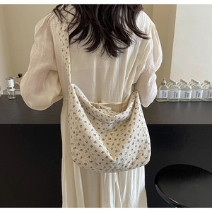 Detail view of floral cotton canvas crossbody bag showing texture and semi-moon shape
