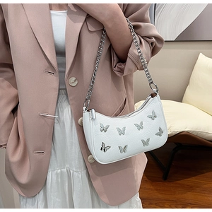 Vue détaillée d'un sac bandoulière en cuir PU blanc avec des breloques papillon argentées