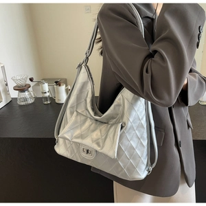 Silver quilted tote bag with metallic finish and matching small pouch on shoulder