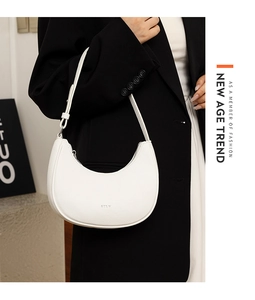 Detailed view of a white leather hobo bag with silver STLY logo and textured finish