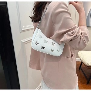 Détail du sac bandoulière blanc en PU avec motifs papillons et chaîne sur le mannequin