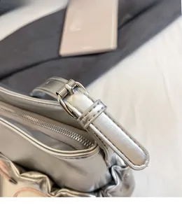 Detailed close-up of adjustable silver metal buckle and pleated PU leather on shoulder bag
