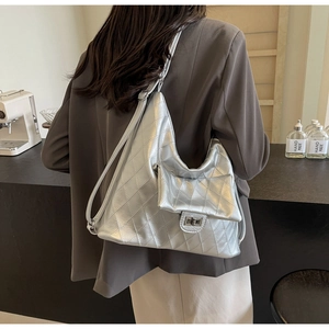 Detail of silver metallic quilted hobo bag with metal lock pocket in urban setting
