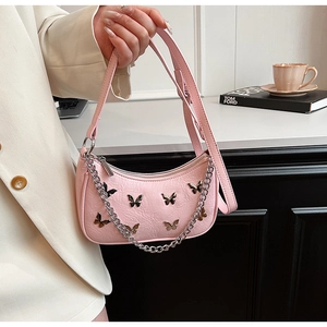 Détail du sac bandoulière en cuir PU plissé rose avec des breloques papillons argentées