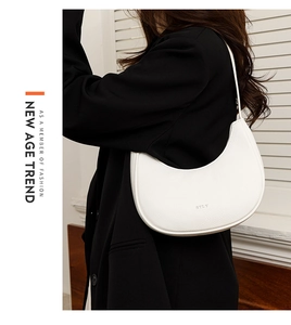 Detail of white leather hobo bag with silver STLY logo worn on person with black blazer