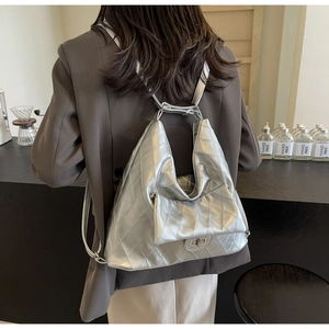 Detail view of the silver quilted PU leather backpack with a classic metal twist-lock closure