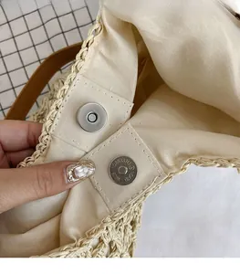 Close-up of straw bag detail featuring cream lining and high-quality metal magnetic closure