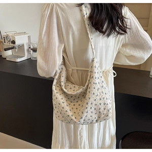 Floral print fabric crossbody bag styled with a white dress in a cafe setting