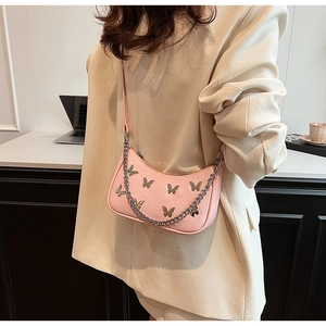 Détail du sac en cuir PU rose avec papillons en métal argenté et décoration de chaîne
