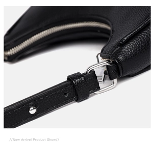 Close-up of pebble grain black leather texture and silver zipper detail on underarm bag