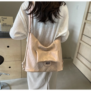Detail of light apricot hobo bag with diamond quilting and metal buckle on the side