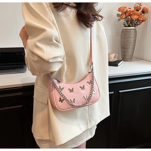 Pink underarm bag detail featuring silver butterfly metal studs and texture