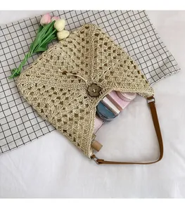 Detail view of woven straw shoulder bag showing interior space with cosmetics and wood button