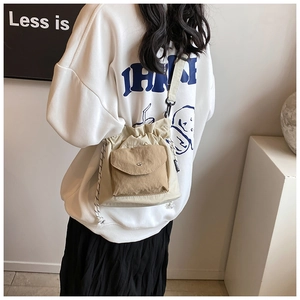 Detail of trendy Oxford fabric crossbody bag featuring a drawstring and front pocket