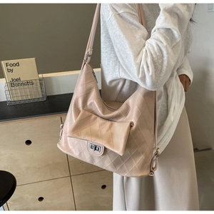 Detail of light pink quilted PU leather shoulder bag with silver metal turn-lock closure