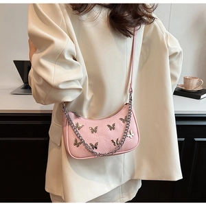 Détail du sac demi-lune en PU rose avec boucles papillon argentées et chaîne en métal