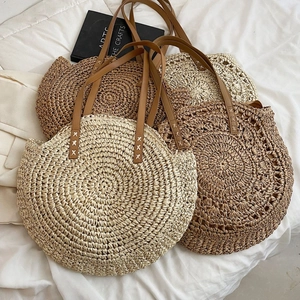 Minimalist round woven straw shoulder bags in brown and beige tones for beach and summer