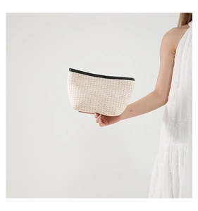 Detail of woven straw and PU texture on cream white tote bag with black edge