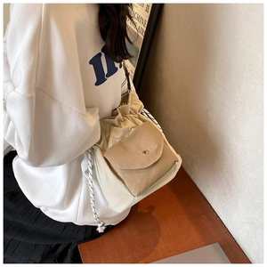 Detail view of beige canvas drawstring crossbody bag showing fabric texture and braided strap