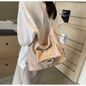 Detail of light pink quilted PU leather crossbody bag featuring a metal twist lock buckle