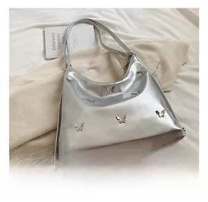 Dettaglio della borsa in pelle PU argento con farfalle metalliche 3D decorative