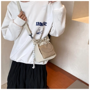 Detail of trendy oxford fabric crossbody bag with adjustable strap and drawstring design