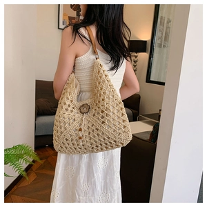 Detailed macro view of woven straw bag with wood flower button and leather strap