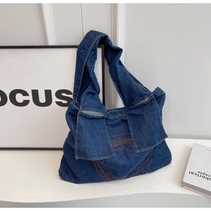 Large capacity navy denim shoulder bag with orange contrast stitching and flap design