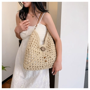 Detail view of woven crochet shoulder bag featuring a dark brown wooden flower button