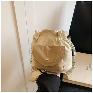 Minimalist beige oxford fabric bucket bag with khaki front pocket and cord strap