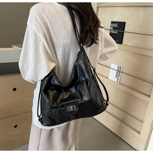 Detail of black quilted PU leather shoulder bag with silver turn-lock clasp and rhombic stitching