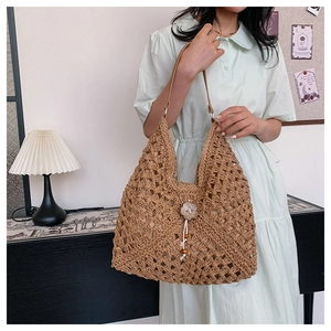 Detail of straw shoulder bag with woven texture, wooden flower button and bead lanyard