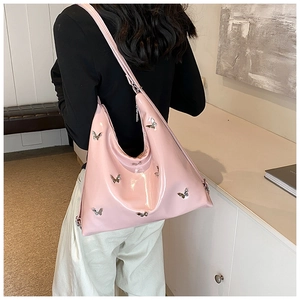 Dettaglio borsa a spalla in vernice rosa con fibbie metalliche a farfalla argentate