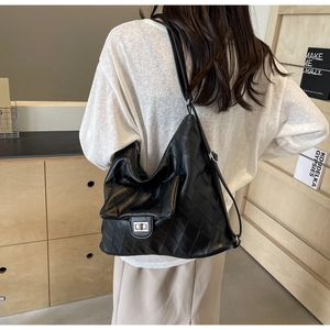 Detailed view of black quilted PU leather shoulder bag with silver twist lock and spacious interior
