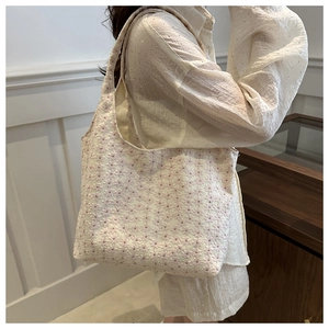 Close-up of beige floral jacquard tote bag with elegant pink flower embroidery details