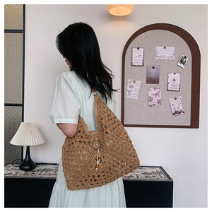Detailed close-up of straw woven tote bag featuring wooden button and crochet texture