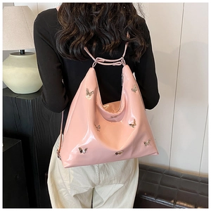 Dettaglio della borsa hobo in vernice rosa lucida con ornamenti a farfalla argentati